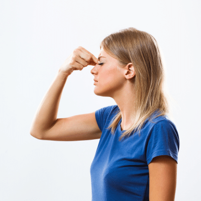 Woman pinching top of nose, dealing with chronic sinusitis